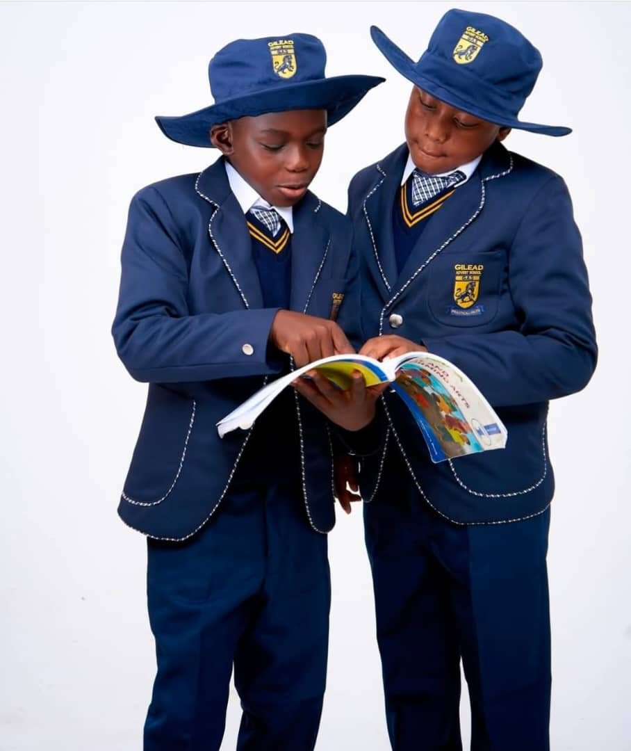 Two NECST-uniformed schoolboys reading together