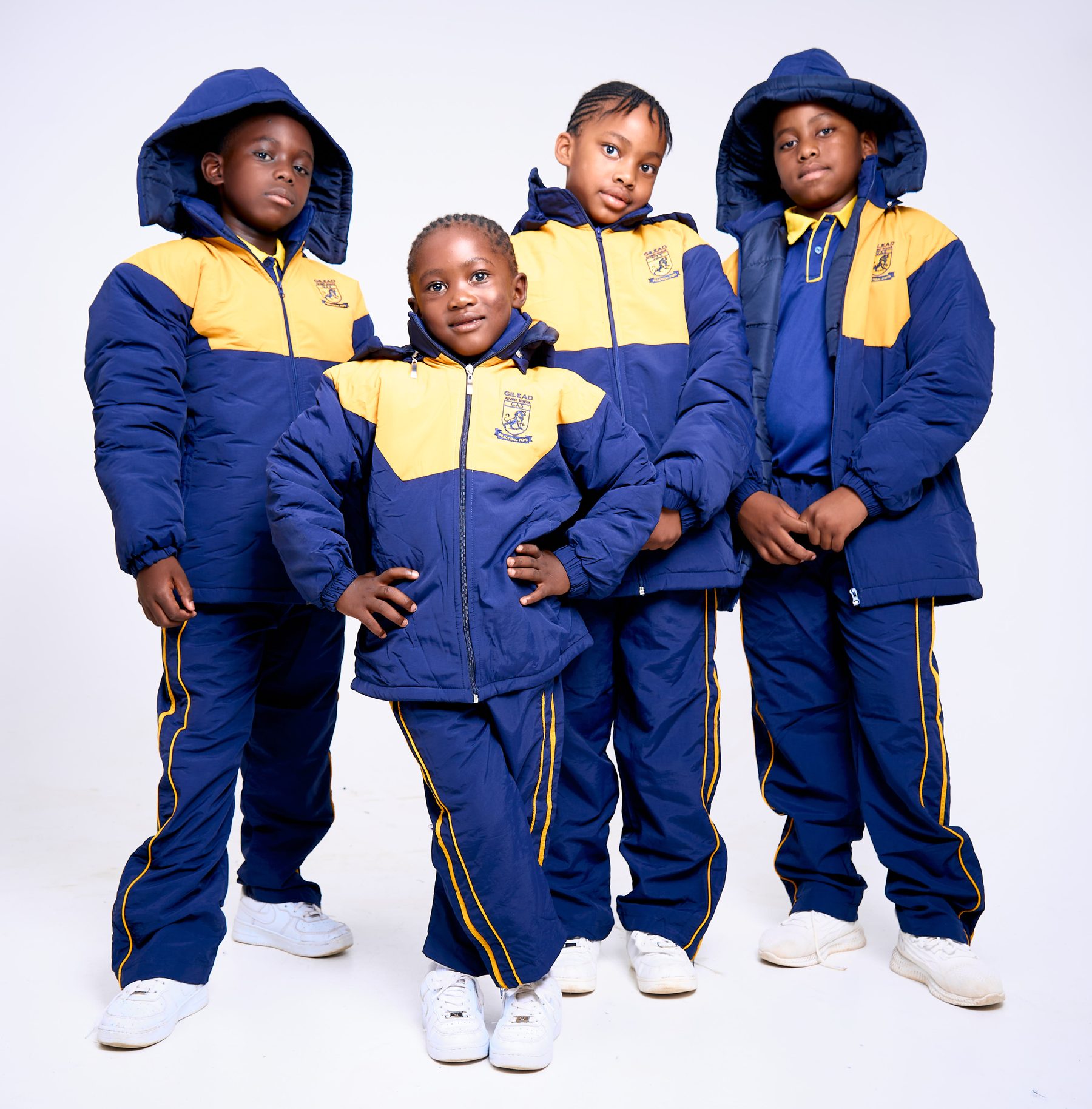 Schoolchildren wearing navy and gold NECST winter tracksuits with hoods